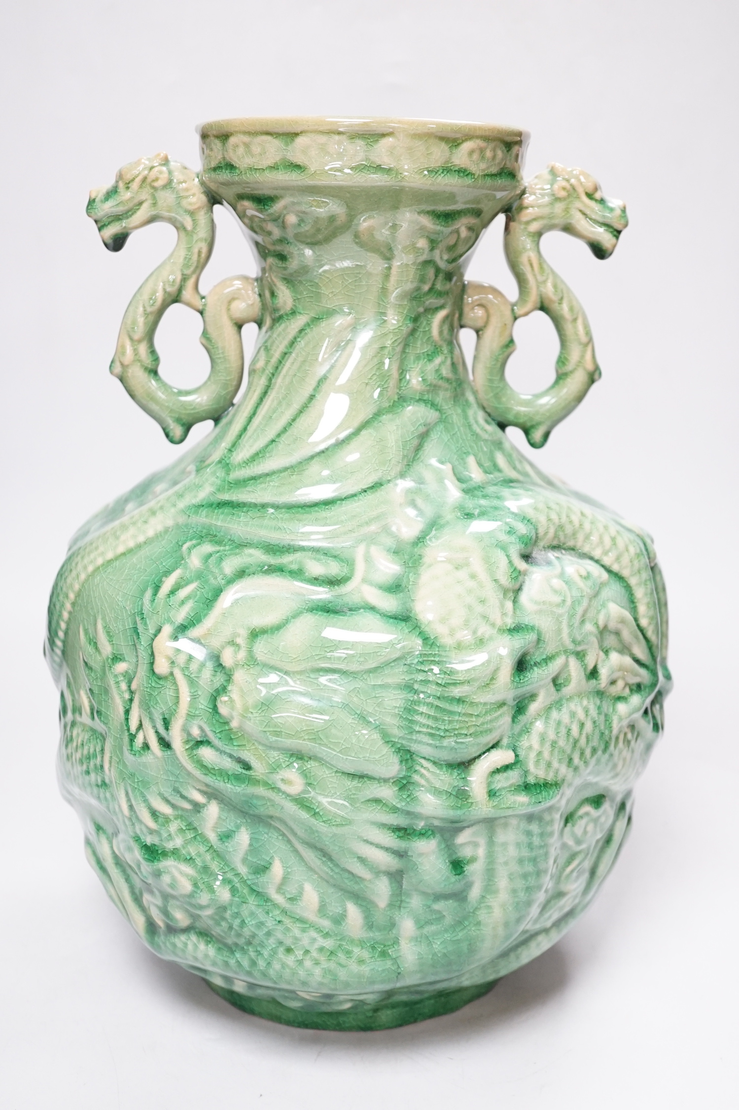 A Chinese green glazed vase with twin zoomorphic handles, decorated in relief with dragons, 35cm high